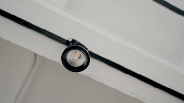 Tavanda ayarlanabilen küçük beyaz, modern minimalist lamba armatürü. Modern beyaz lamba. Işıklandırma ekipmanlarıyla minimalist iç mekan.