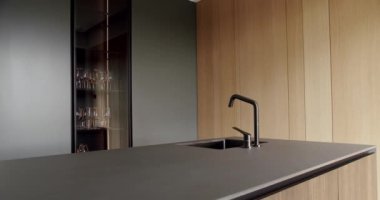 Minimalist yemek masası olan modern mutfak odası. Modern lavabosu olan yerli mutfak. Modern Açık Konsept Ev İçi. Minimalist mutfak odası beyaz renklerde ve yemek alanı da doğal ahşap.