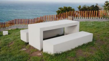 Modern beton piknik masası ve banklar Portekiz 'de manzaralı bir okyanus manzarasına karşıdır. Açık hava rahatlığı ve doğanın takdir edilmesi için idealdir. Modern Beton Piknik Tablosu