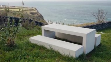 Beton piknik masası ve banklar Portekiz 'e bakan çimenli bir tepenin üzerine kurulmuş. Açık hava rahatlığı ve manzaralı manzaralar için ideal. Grassy Cliff 'te Okyanusa Bakan Somut Piknik Masası