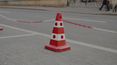 Park yeri konisi ve bölgenin sınırlandırılması için. Trafik konisi. Şehir parkındaki kaldırımda renkli trafik konileri. Yenileme, koruyucu bant. Kaldırımda trafik konisi..