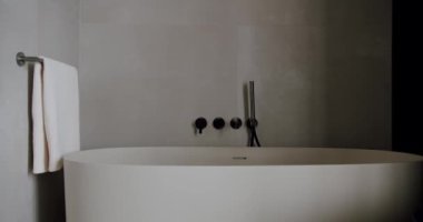 Rahatlatıcı minimalist bir banyo, serbest banyo, parlak eşyalar, ve beyaz bir havlu, çağdaş bir ortamda zarafet ve rahatlamayı çağrıştırıyor. Modern Minimalist Banyo İçi