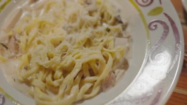 İtalyan makarnası. Carbonara peynirli spagetti. Parmesan peynirli beyaz kase. Yaklaş. Restoranda yemek. Fettuccine makarna pişiriyorum. İtalyan mutfağı. Yemek arkaplanı. Lezzetli yemekler. Spagetti Cabonara Jambonlu Peynir.