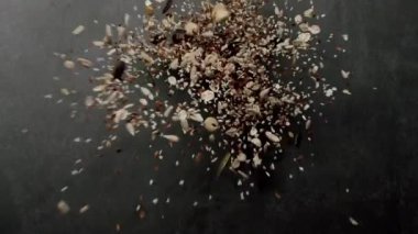 Havadaki çeşitli sağlıklı mısır gevrekleri ve fındıkların dinamik görüntüsü canlı bir gıda konseptini gösteriyor tazeliği, sağlığı ve organik besinleri vurguluyor. Sağlıklı mısır gevrekleri ve fındıklar havada uçuşuyor