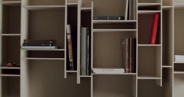Düzenli bir şekilde kitap koleksiyonunu gösteren çağdaş bir kitaplık. Açık raflar geniş bir depolama sağlar, minimalist ve modern bir estetik tasarım sergiler.