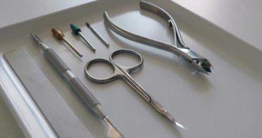 Çivi bakım aletleri. Profesyonel aletler, tırnak törpüsü, makas, meme uçları ve manikür için kuaför. Tırnak bakımı prosedürü için tepside steril aletler.