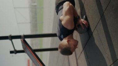 Fitness odaklı bir adam dışarıda bir ilaç topuyla gayretle egzersiz yapar. Sabah ışığı altında güç ve dayanıklılık gösterir. Gelişmiş Tıp Balosu Egzersizi Yapan Atletik Adam. Dikey