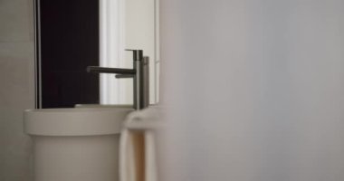 Minimalist beyaz bir lavabo, parlak bir musluk ve şık bir sabun makinesinin bulunduğu çağdaş bir banyo. Yumuşak ışıklandırma ve temiz tasarım basitlik ve zarafeti çağrıştırıyor. Zarif Modern Tuvalet