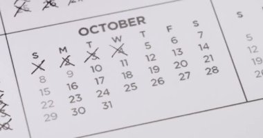 Ekim ayı takvimine ayın günlerini çizmek için siyah kalem kullanan bir kişi. Bu kavram zaman, son teslim tarihi ya da programlar hakkında temalar için kullanılabilir. Ekim Takviminde Tarihler Siliniyor