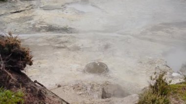 Portekiz, Sao Miguel 'in volkanik manzarasında dumanı tüten fümerol. Sis, jeotermal aktiviteyi ve bölgenin benzersiz doğasını vurgulayan bir dünya dışı atmosfer yaratıyor..