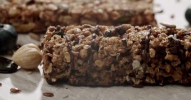 Fındık, tohum ve yaban mersinli bir granola barın ağız sulandırıcı yakın çekimi sağlıklı bir aperatif veya kahvaltı için lezzetli ve besleyici cazibesini vurguluyor. Yabanmersinli ve fındıklı granola çikolataları.