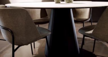 Kumaşı kapat ve yuvarlak yemek masalı modern kahverengi koltuğu kapat. Modern Minimalist Evi. Zarif ve rahat bir ev, sıcak bir ortam. Modern bej koltuk. İç Güvenlik Bölümü. Modern sandalye, masa.