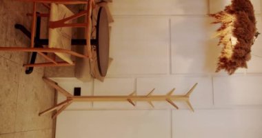 Tahta sandalye ve masa. Eco Friendly Cafe. Kafedeki modern ahşap kumaş sandalye ve masa mobilyası. Dikey video. Ahşap sandalyeli, tekstil malzemeli ve siyah masalı modern minimalist kafe..