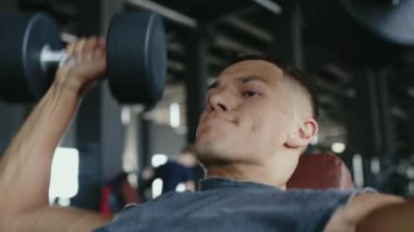 Spor salonunda sıkı antrenman yapan, kendini adamış, güçlü ve formda bir sporcu. Odaklanmış Adam Spor Salonunda Ağırlık Kaldırıyor Güç Antrenmanı ve Fitness. Adanmış Atletizm Eğitimi