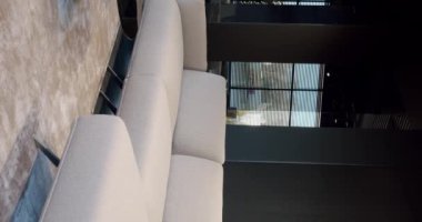 Bej ve beyaz mobilyalı modern Minimalist oturma odası. Konforlu Modern Ev İçi Köşesi Koltuklu, rahat Modern Mobilya Tasarımı. Gayrimenkul özel evi. Dikey video.