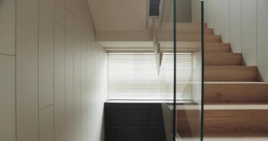 Beyaz duvarları ve merdivenleri aydınlatan Venedik kör pencereli minimalist ahşap bir merdiven. Modern iç tasarım temaları için mükemmel. Modern Minimalist Tahta Merdiven
