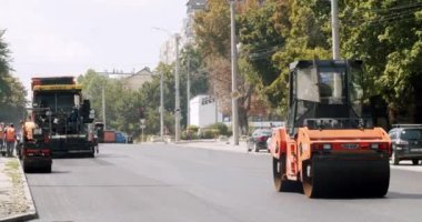 Yol yapım asfalt kaldırım taşları yeni bir asfalt katmanı oluşturuyor. Yol silindirleri yeni bir yola çıkıyor. Yol tamiri. Ağır makineler. Yol inşaatında asfalt kaldırım makinesi.