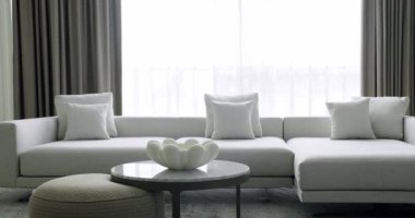 Modern contemporary Minimalist living room with white and gray furniture and round table. Luxury Modern House Interior With Corner Sofa and Bookshelf. Cozy Modern Furniture Design. Luxury Elegant Room