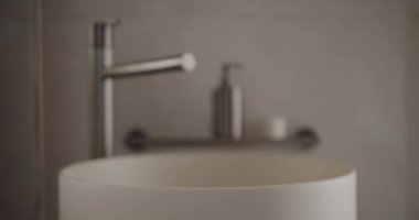 Zarif ve modern banyo lavabosu ve paslanmaz çelik musluğu. Nötr tonlu ortamdaki minimalist tasarım rahatlatıcı ve zarif bir atmosfer yaratır. Modern Banyo Lavabosu