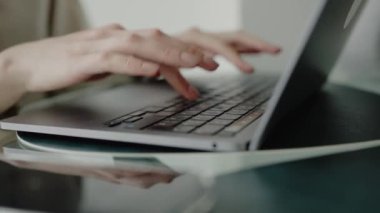 Bilgisayarda el yazısının yakın plan görüntüsü, uzaktan çalışmayı, ofis görevlerini veya çevrimiçi iletişimi resmetmek için ideal. Modern bir Ofis Ayarında Dizüstü bilgisayarda Yazan Ellerin Kapanışı