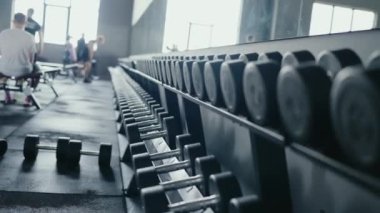 Spor salonundaki bir sıra dambılın yakın çekimi. Spor aletlerini, egzersiz ortamını ve egzersizleri vurguluyor. Fitness, eğitim ve sağlıkla ilgili kavramlar için mükemmel. Fitness Ekipmanı Odaklanma
