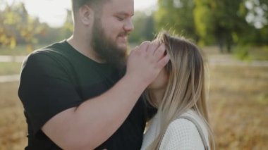 Genç bir erkek ve kadın, güneşli bir parkta sevgi ve yakınlık gösteren hassas bir anı paylaşıyorlar. Aşk ve ilişkilerle ilgili kavramlar için idealdir. Parktaki Genç Çiftler Arasındaki Hassas an