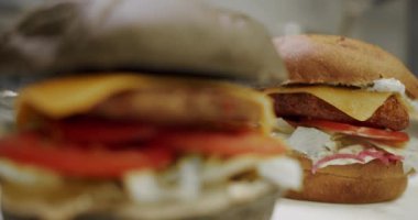 Lezzetli fast food konsepti. Köfteli hamburger, domates, salatalık, marul. Hamburger pişiriyorum. Yakın plan. Profesyonel Lokanta Mutfağında Yemek Pişirme.