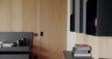 Ahşap duvarlı ve gri mobilyalı modern Minimalist oturma odası. Rafları ve kitabı olan samimi, modern mobilya tasarımı. Köşedeki kanepe ve kitaplığı olan Modern Ev İçi.