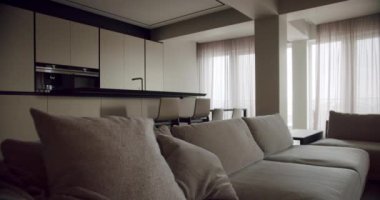 Şık ve modern bir oturma odası rahat koltuklar, gösterişli bir mutfak alanı ve havadar havayı arttıran yumuşak perdeler. Konfor ve tasarımın mükemmel bir karışımı. Zarif Modern Oturma Odası İçi.