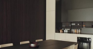 Karanlık Ahşap Aksanlı Modern Minimalist Mutfak. Çağdaş mutfak vitrinleri koyu ahşap paneller ve parlak mobilyalar ile minimalist tasarım, harmanlama işlevselliği ve stili.