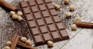 Fındık ve tarçınlı çubuklarla kaplı zengin bir sütlü çikolata. Yemekler ve çikolata severler için ideal. Fındık ve Tarçın Çubuklu Lezzetli Çikolata