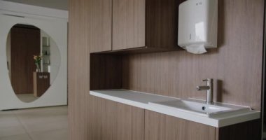 Beyaz lavabosu, ahşap dolapları ve büyük, benzersiz bir aynası olan temiz ve şık modern bir banyo. Modern yaşam ilhamları için mükemmel. Modern Tuvalet İçi
