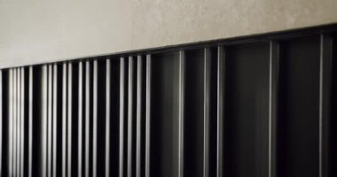 Dokulu bir duvardaki modern siyah radyatörün detaylı görüntüsü minimalist ve çağdaş iç tasarım tarzları sergiliyor. Mimari ve ev dekorasyonu teması için mükemmel.