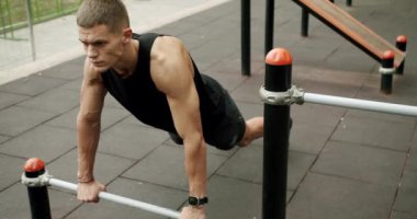 Sportif adam spor sahasında kol kaslarını çalıştırıyor ve eğitiyor. Spor ve spor yaşam tarzı. Spor, sağlık, spor, spor, spor. Güç, motivasyon. Açık hava spor salonu.