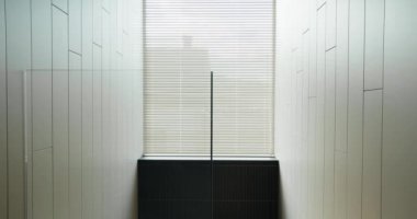 Zarif, minimalist, gösterişli, parlak beyaz dolaplar ve yumuşak ışıklı bir odada yatay pencere perdeleri, çağdaş zarafeti somutlaştırıyor. Pencere Perdeleri ile Modern Minimalist Tasarım