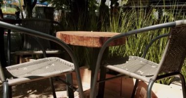 Sokaktaki kafede siyah modern Charis 'li ahşap masalar. Sokak kafesi. Modern Terrace. Boş restoran. Yaz sabahları boş bir kafe. Modern açık hava kafesi..