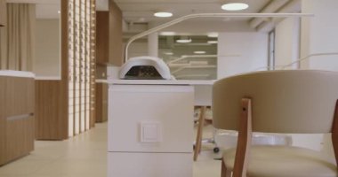 Çağdaş bir manikürcüde modern bir çalışma istasyonu ve şık bir sandalye gösterişli bir minimalist lambanın altında karşılama alanı yaratıyor. Modern Manikür Salonu Mobilya ve Mobilya Dükkanı