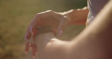 Bir kadın spor yapıyor ve açık havada saatleri kontrol ediyor, kalp atışı ya da zindelik. Tuş takımı ve kalp atış hızı monitörü olan akıllı bant. Akıllı saat ekranı ile el ve bilek yakın çekim