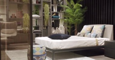 Duvarında modern siyah ahşap duvar kağıdı olan lüks bir ev. Kral yatağı olan zarif ve basit bir yatak odası. Minimalist yatak odası. Çift yatak ve yastıklı mobilyalarla modern yatak odası..