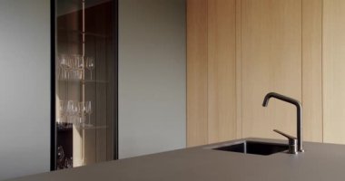 Açık Ahşap Duvar ve Zemin. Modern mutfak ve bar kahverengi sandalyeler minimalist dairede mutfak odasında. Minimalist yemek masası olan modern mutfak odası. Modern lavabolu Ev Mutfağı.