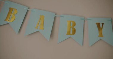 Bebek odasındaki duvarda süslü bayraklar asılı, kutlama süslemeleri. Çocuk odası dekoru. Yeni doğan selamlama konsepti. Odada kutlama yaparken renkli bayraklar.