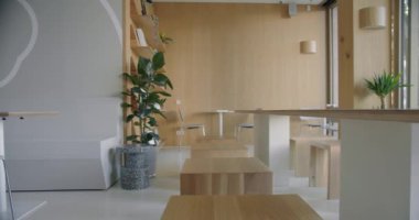 Parlak ahşap mobilyalar ve canlı kapalı alan bitkilerinin yer aldığı sakin ve şık bir modern ofis ortamı. Çağdaş şirket içlerini tasvir etmek için ideal..