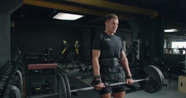 Modern Spor Salonu 'na odaklanmış Genç Adam Egzersizi. Odaklanmış genç beyaz erkek iyi donanımlı, modern bir spor salonunda spor yapıyor..