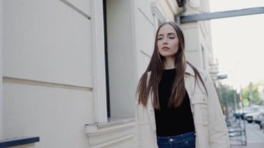 Kendine güvenen, uzun saçlı, şık bir şehir ortamında gezen, günlük kıyafetler giyen genç bir kadın. Kentsel Ayarlar 'da Kendine Güvenen Genç Kadın Poz Veriyor