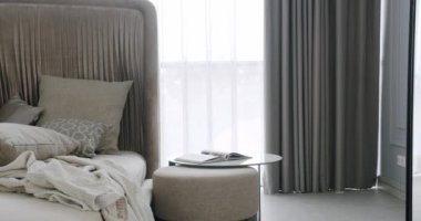 Modern Hotel Yatak Odası İçi ve Yastıklı Yatak. Minimalist İskandinav tarzı iç mekan. Büyük yataklı bir yatak odası. Zarif iç tasarım. Minimalist Kahverengi ve Gri Yatak odası.