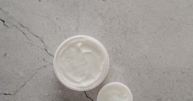 Doğal malzemelere dayalı kozmetik yağları cilt bakımı için doğal kozmetik ürünleri. Kremalı parlak kozmetik kavanozu. Gri arka planda kozmetik ve güzellik tedavisi için kavanozlar, şişeler ve tüpler.