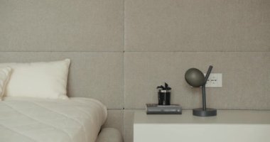 Rahat bir yatağı, zarif bir lambası ve nötr renkleriyle temiz bir tasarımı olan zevkli bir minimalist yatak odası. Huzurlu bir ortam için mükemmel. Minimalist Tasarımlı Modern Yatak Odası