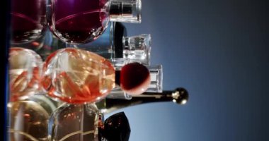 Zarif tasarımı ve yansıtıcı yüzeyleri olan çeşitli parfüm şişeleri koleksiyonu. Görüntü, lüks bir ortamda renkli cam kaplar yakalıyor ve zenginlik ve zarafet hissi veriyor..