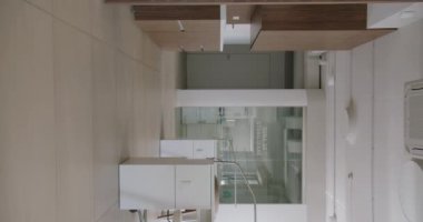 Zarif cam bölümleri, minimalist mobilyaları ve sofistike bej renk paleti olan şık ve şık modern bir ofis. Modern Ofis İç Tasarımı. Dikey video.