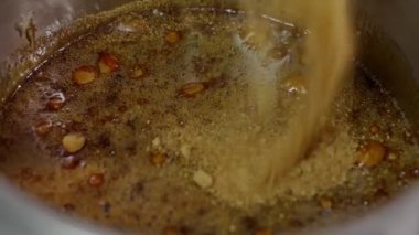 Kahverengi şeker ve eritilmiş karamelin yemek kabında yakın plan görüntüsü, şekerin tatlı hazırlığı için eridiği anı yakalıyor. Tatlı olarak pişirme kabına esmer şeker dökülüyor.